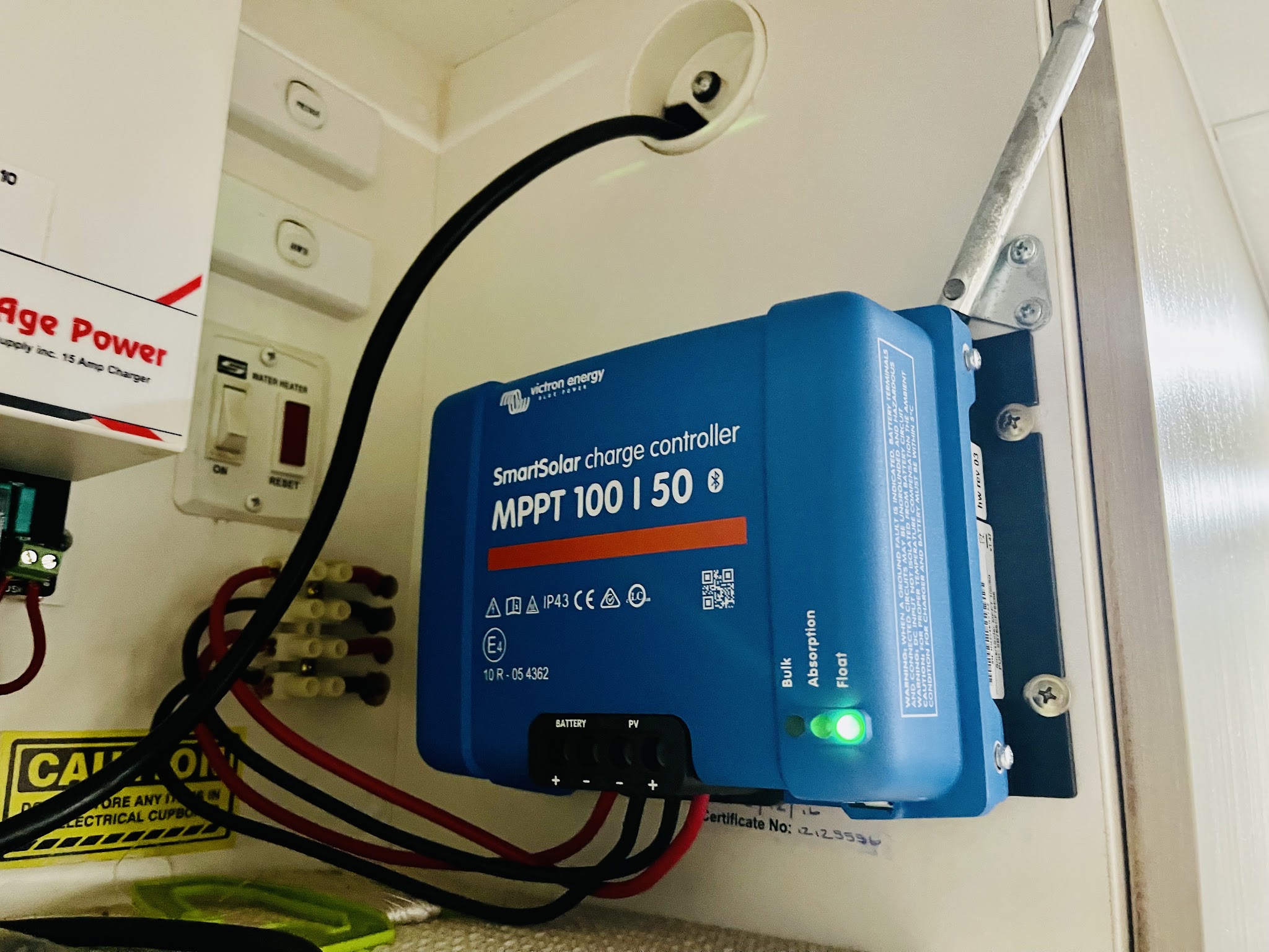 A Victron SmartSolar MPPT 100/50 charge controller mounted in a caravan cupboard, float light showing green